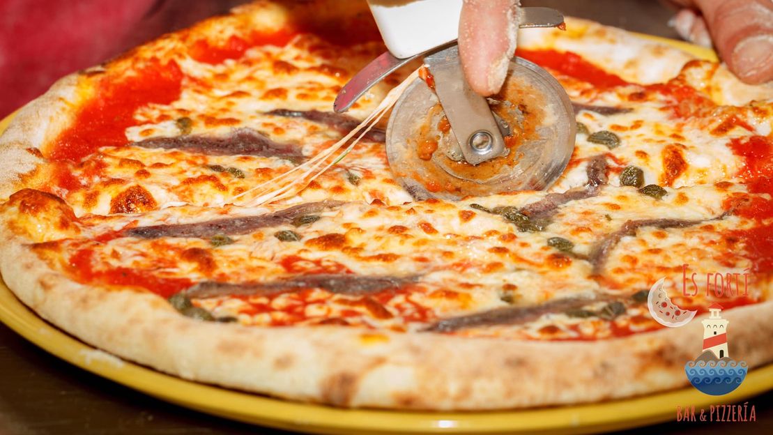 pizza cortándose por Bar & Pizzería Es Fortí